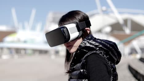 Focused-young-woman-using-VR-headset